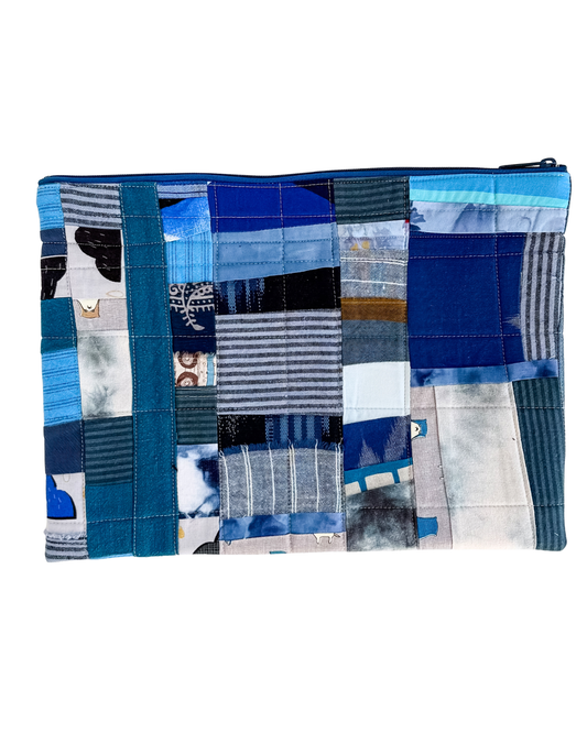 Patchwork laptop case with blue and gray pattern on a white background