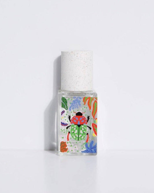 A small, clear bottle of eau de parfum with a colorful, floral design label. The cap is white.