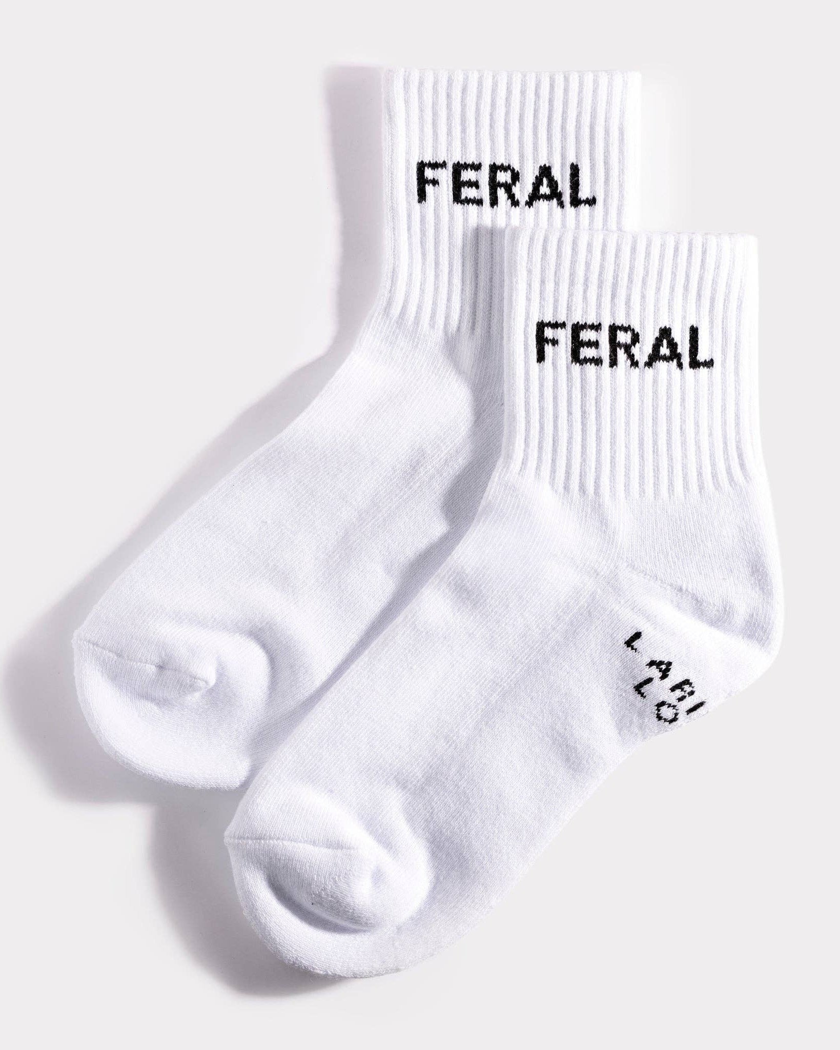 White socks with 'FERAL' branding on a light gray background
