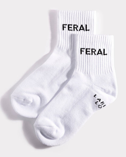 White socks with 'FERAL' branding on a light gray background