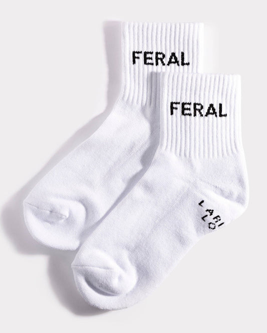 White socks with 'FERAL' branding on a light gray background