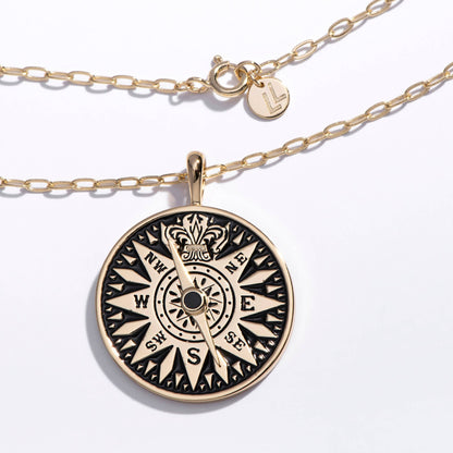 Gold necklace with a compass pendant on a white background