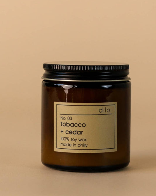 Soy wax candle in a glass jar with scents of tobacco and cedar.