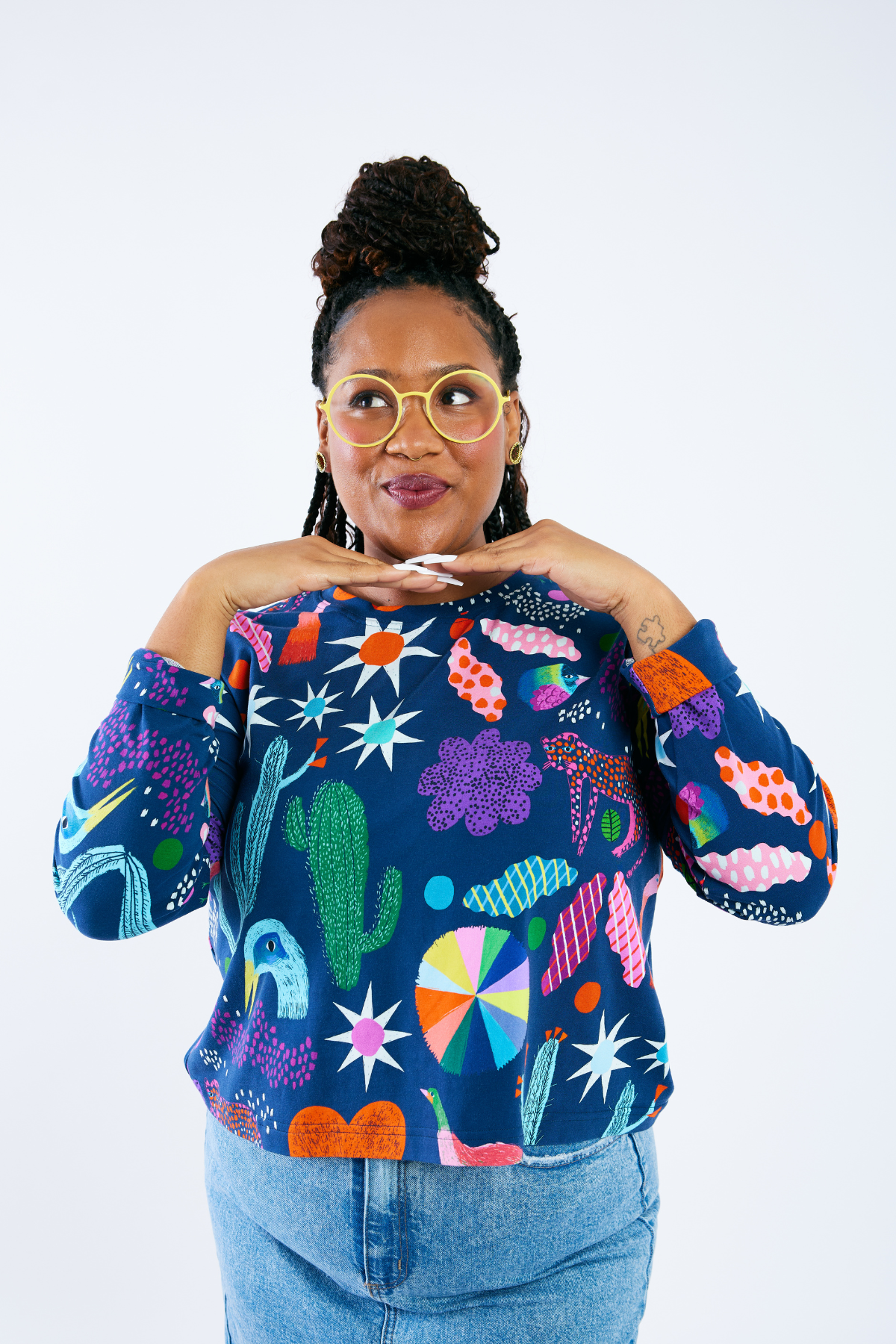Woman wearing a colorful shirt with abstract patterns  and colorful glasses by Eye Spy Optical on a white background