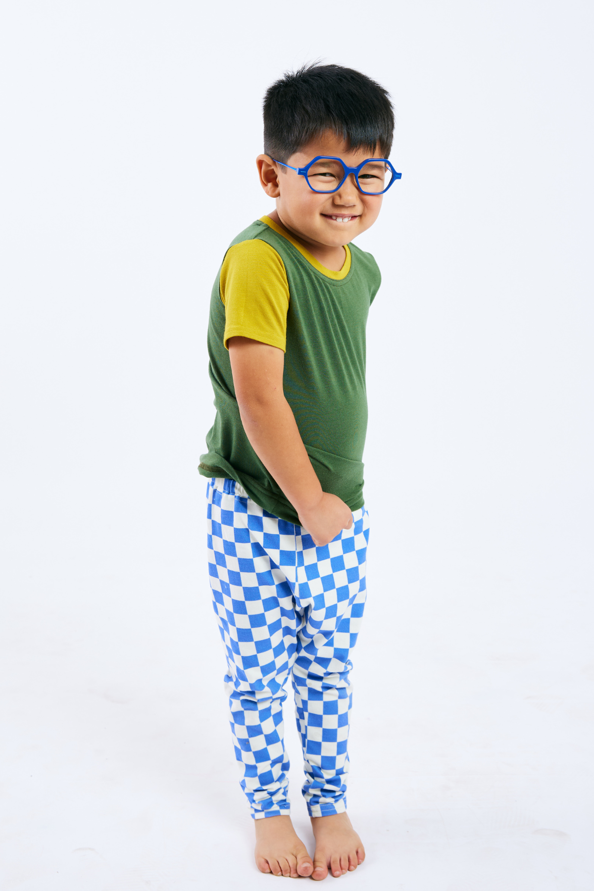 Child wearing sustainable green and yellow t-shirt, organic blue & white leggings,  and blue glasses from Eye Spy Optical