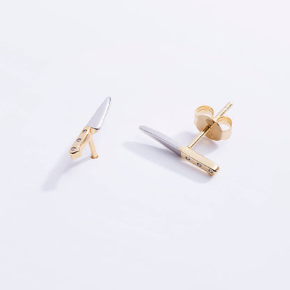 Gold and silver knife earrings on a white background
