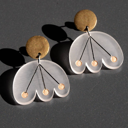 Pair of earrings with gold and frost components on a dark background