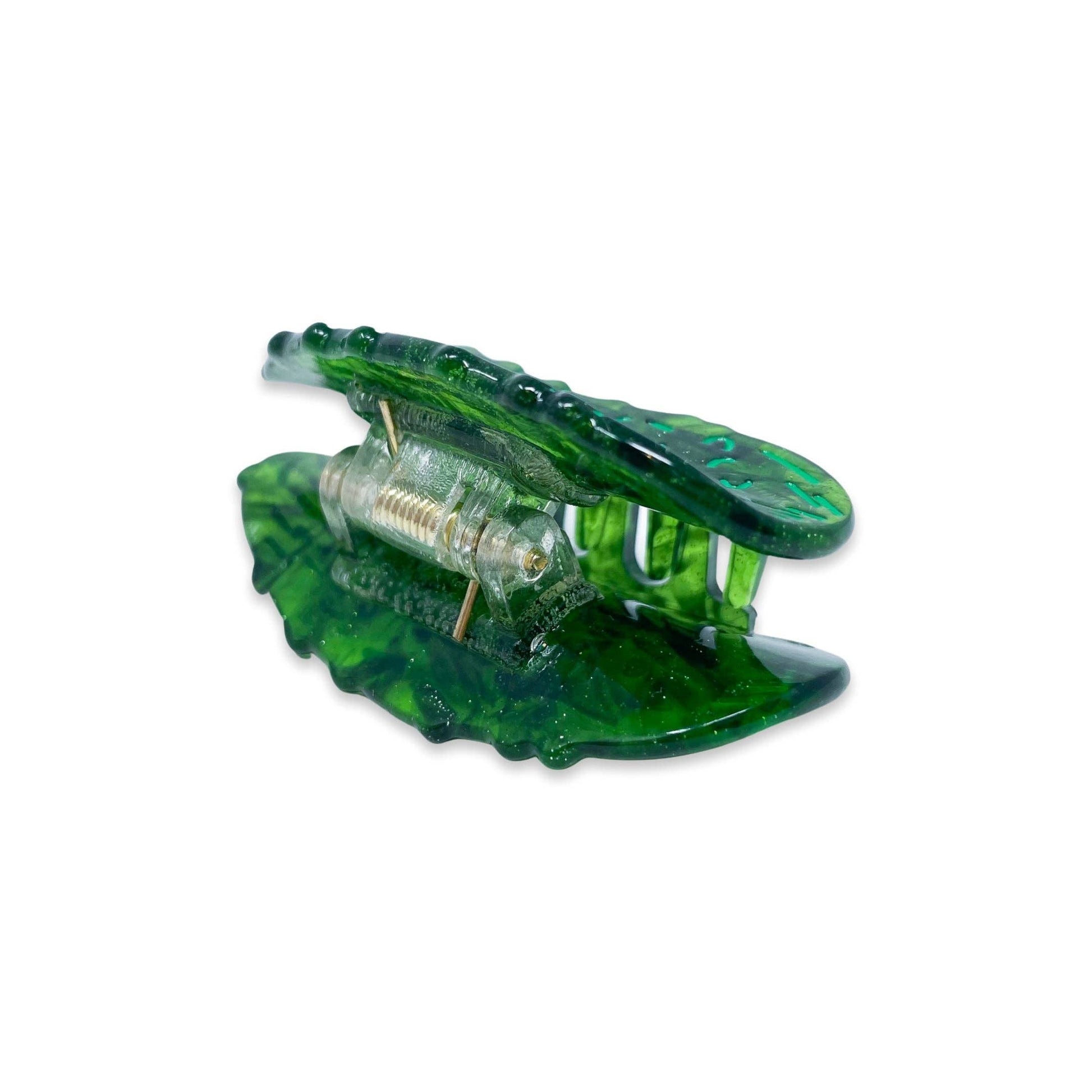 Green pickle hair clip with a clear acetate component on a white background