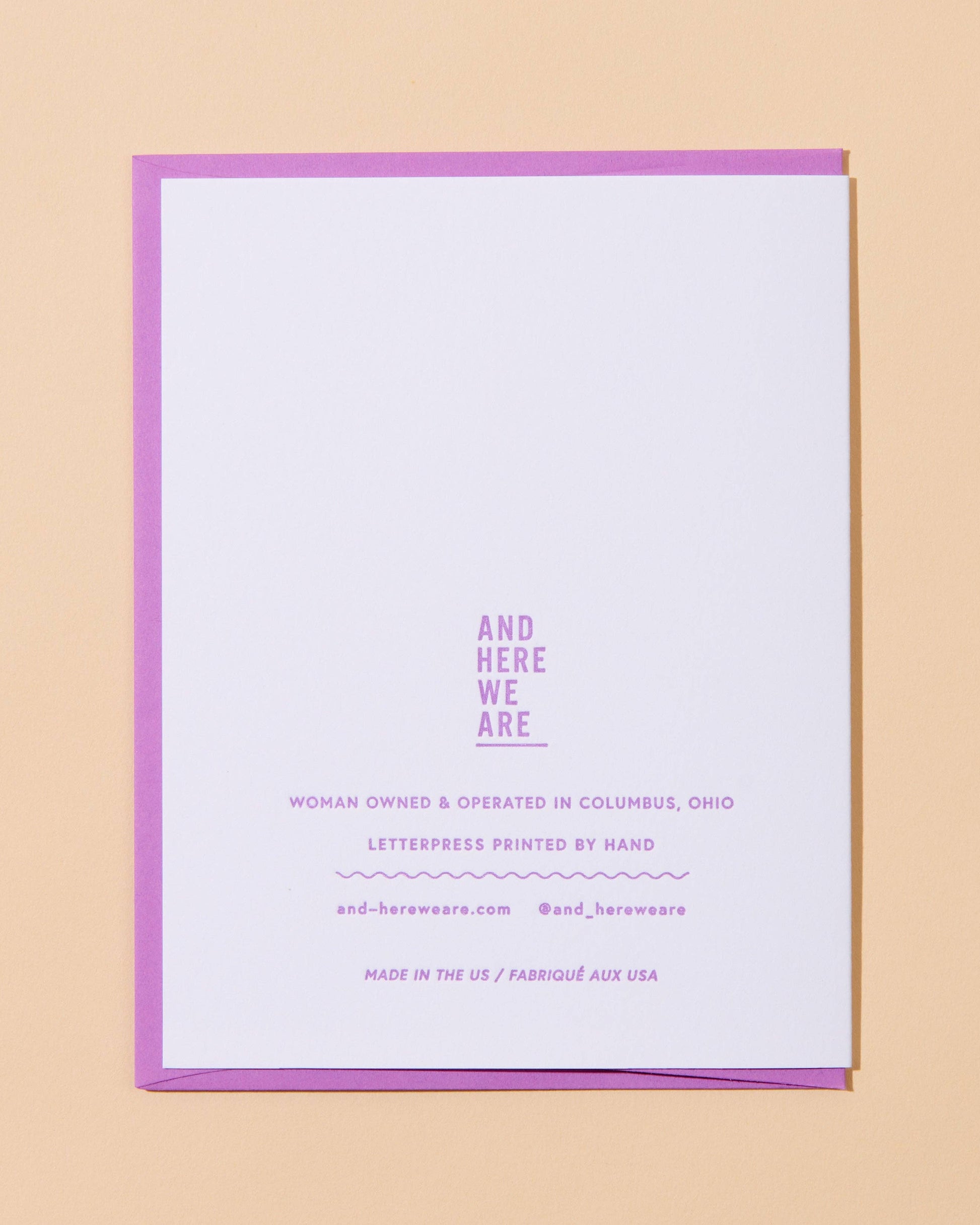White card with purple border and text on a beige background