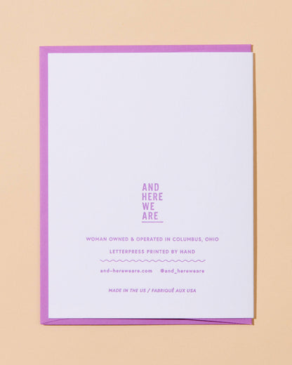White card with purple border and text on a beige background
