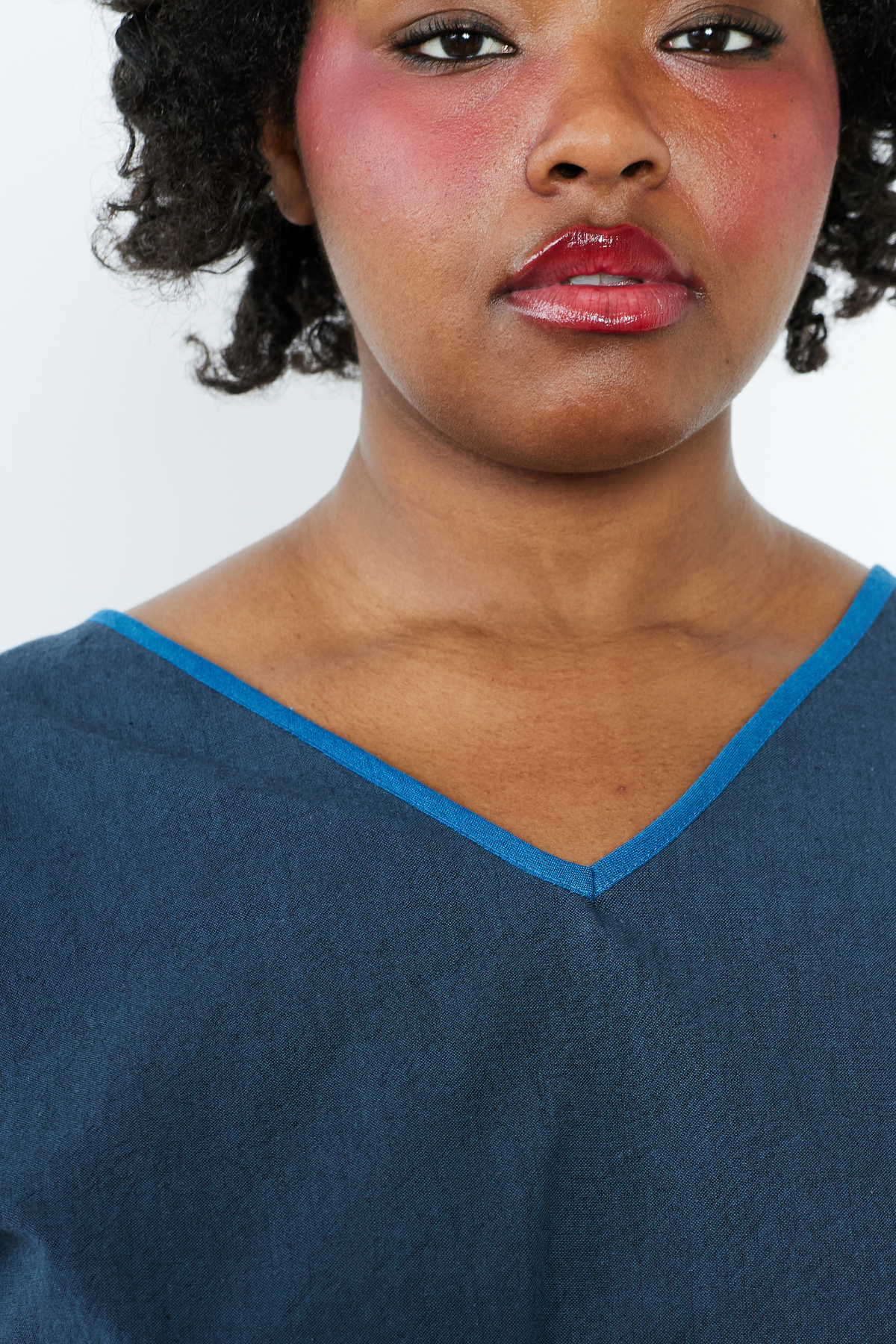 Woman wearing a blue top with a white background