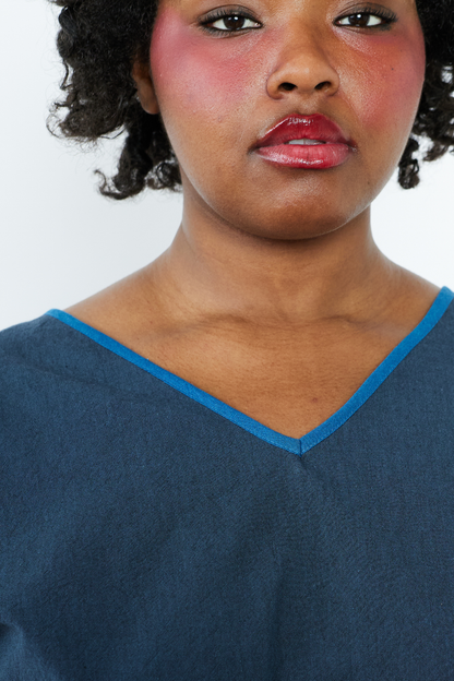 Woman wearing a blue top with a white background