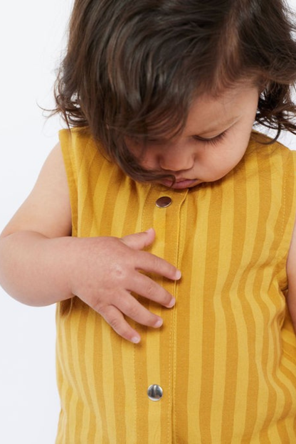 Child wearing a yellow striped shirt with buttons on a white background