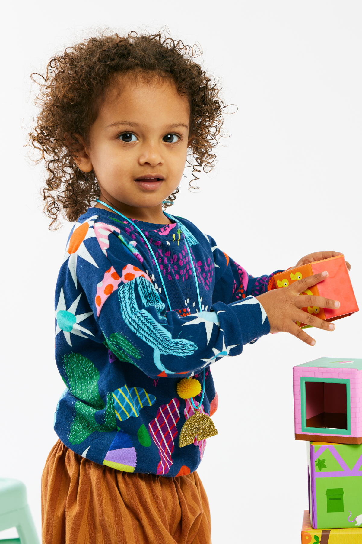 Child wearing a sustainable and soft kid top and striped pants by Lilla Barn Clothing