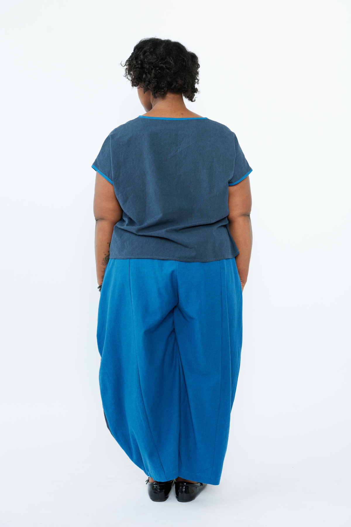 Person wearing a blue outfit with a plain background