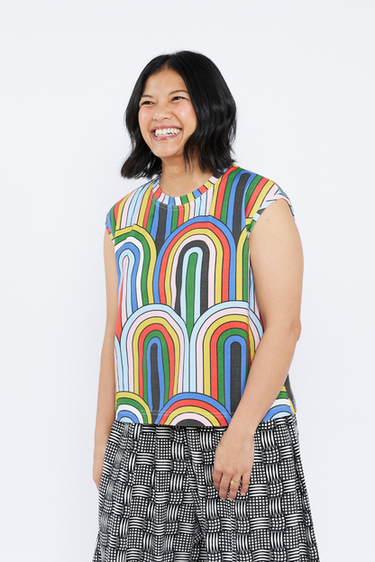 Woman wearing a colorful sleeveless top with a white background