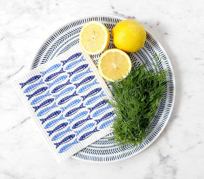 swedish dishcloth with blue sardine design on a white marble counter