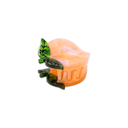 Eco-friendly peach shaped mini hair clip with green leaves on a white background