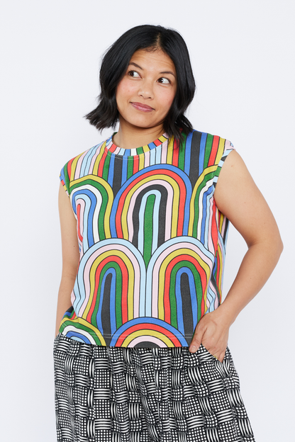Woman wearing a colorful sleeveless top with a white background