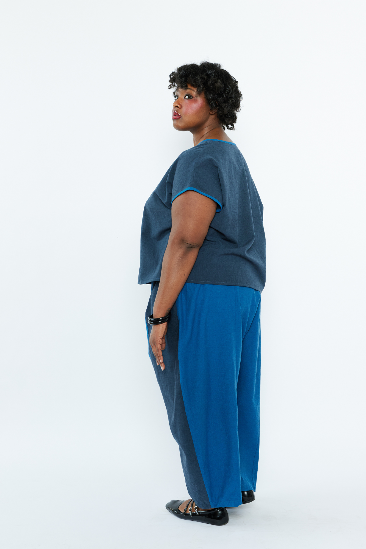 Person wearing a blue outfit with a plain white background