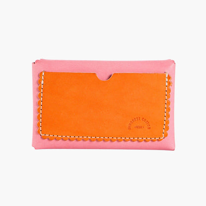 Pink and orange leather cardholder with on a white background