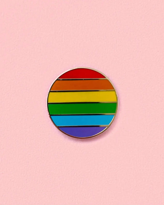 Round rainbow-colored pin on a pink background