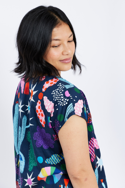 Woman wearing a colorful patterned shirt on a white background