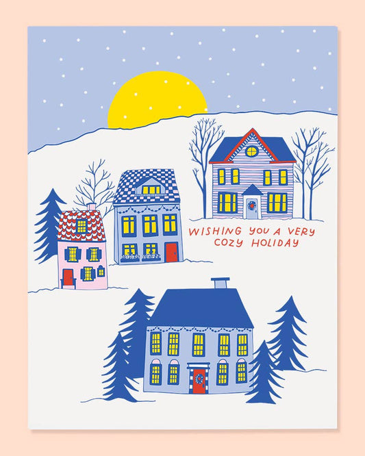 Holiday greeting card featuring a Winter scene with houses and trees, featuring a snowy landscape and a yellow sun.