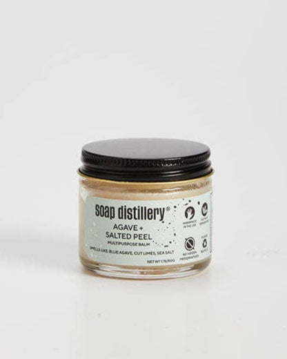 Jar of multi-purpose skin balm with a black lid on a white background