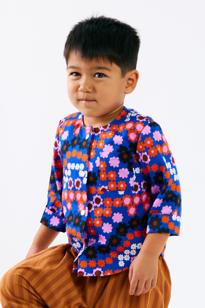 Child wearing a colorful floral shirt on a white background