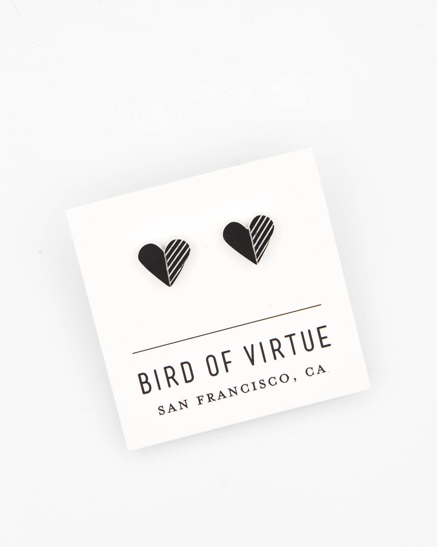 Black heart-shaped earrings and 'Bird of Virtue' branding on a white background