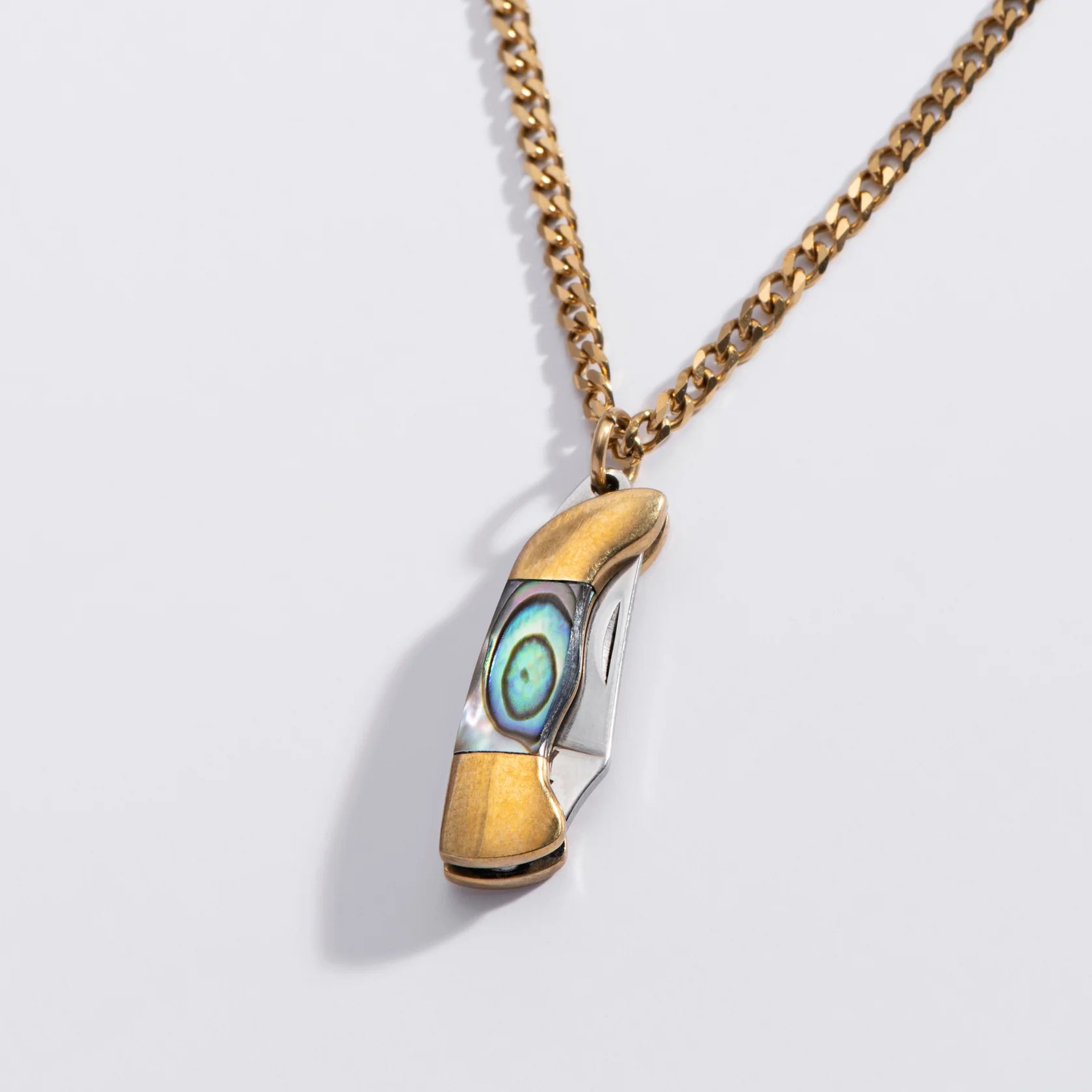 pocket knife pendant with abalone on a light gray background