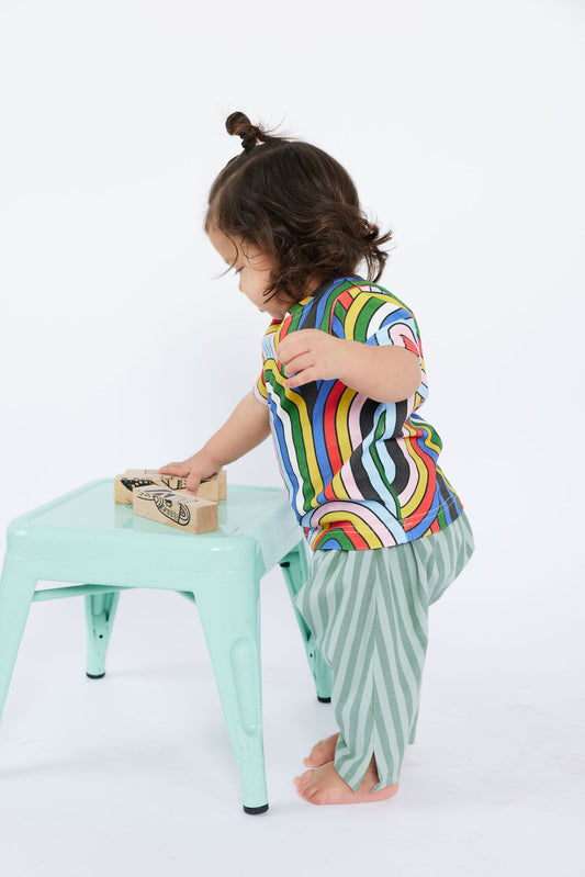 Child playing with toys on a small table against a white background