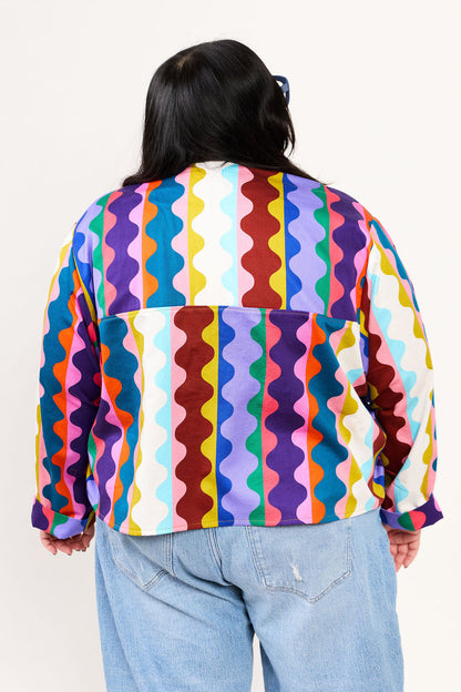 Plus size person wearing a colorful Lilla Barn shirt on a white background