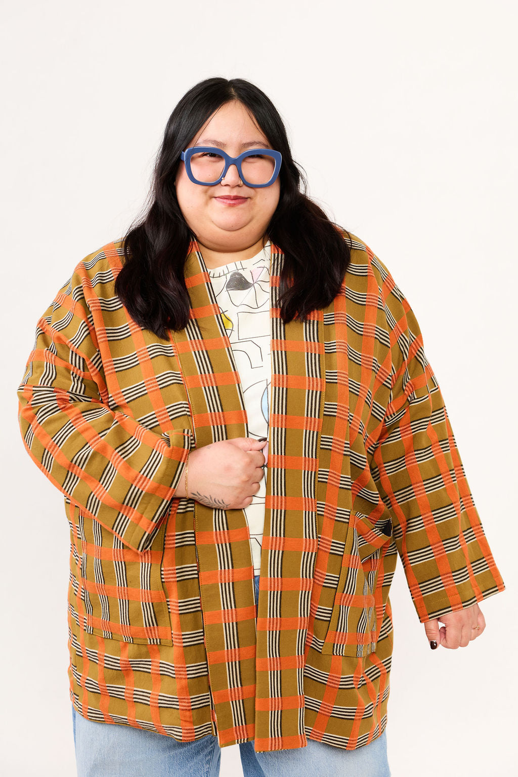 Person wearing a plaid coat with a white background