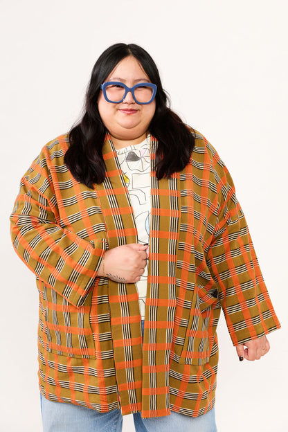 Person wearing a plaid coat with a white background