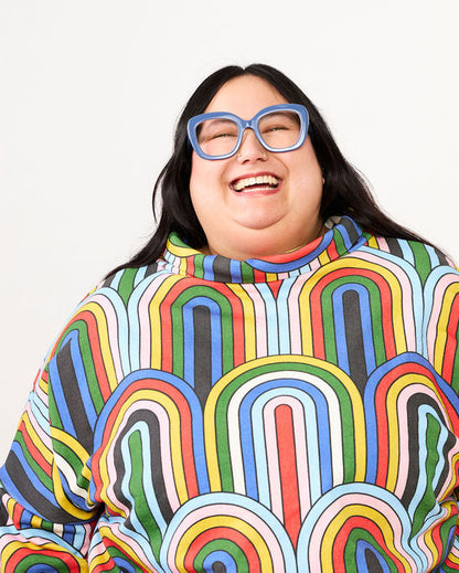 Person wearing a colorful, patterned sweater on a white background