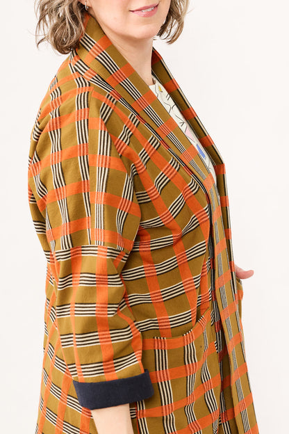 Plaid jacket with orange, brown, and black pattern on a white background