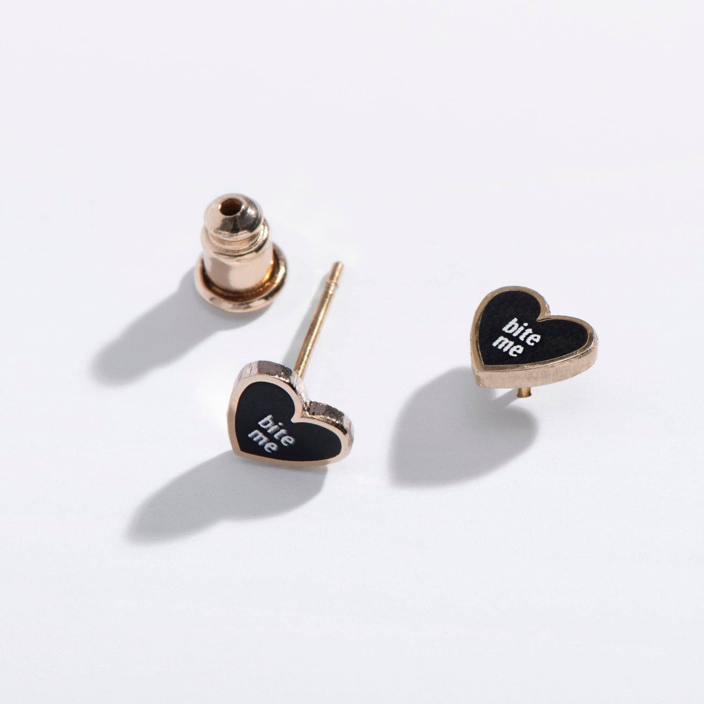 Heart-shaped earrings with 'bite me' text on a white background