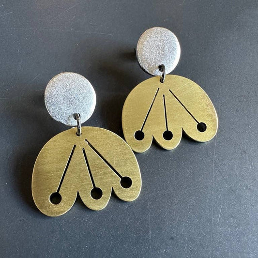 Pair of Scandinavian floral gold and silver earrings on a dark background