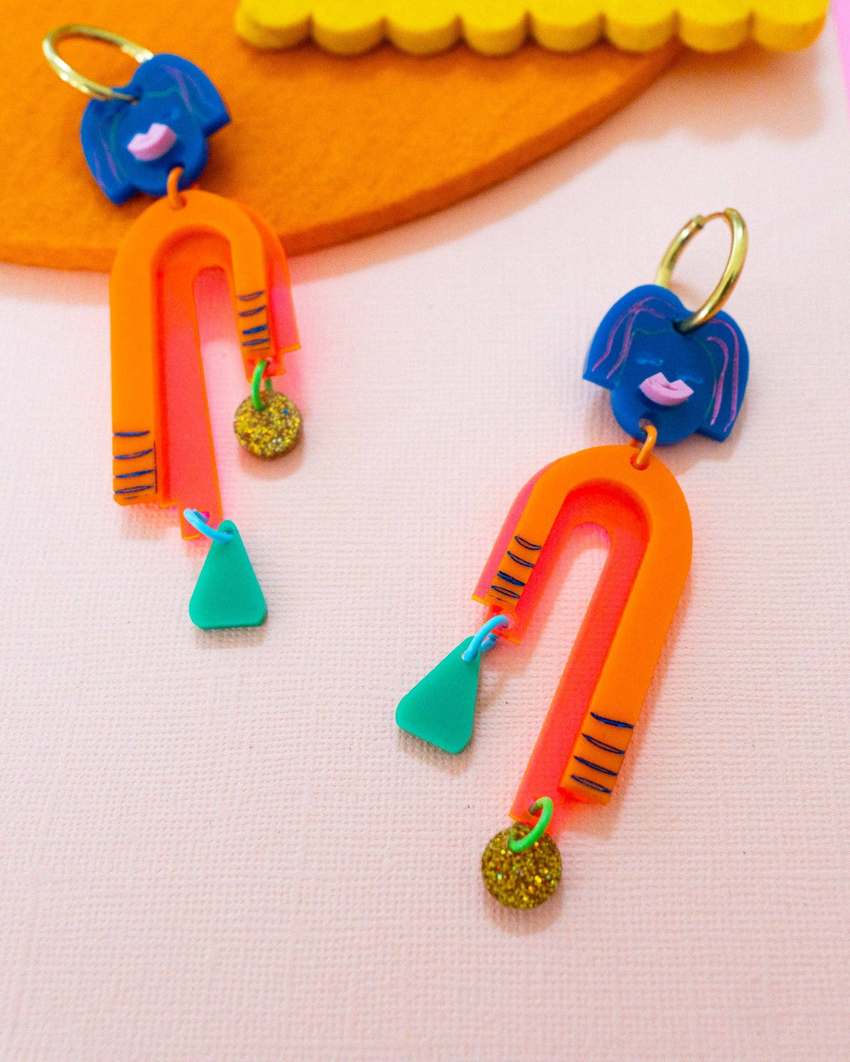 colorful dangly earrings made of acrylic and gold-plated stainless steel. 