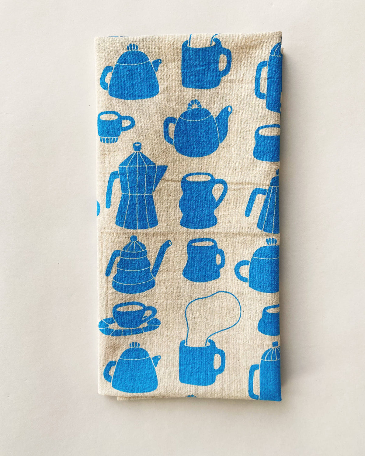 Beige towel with blue tea-related illustrations on a beige background
