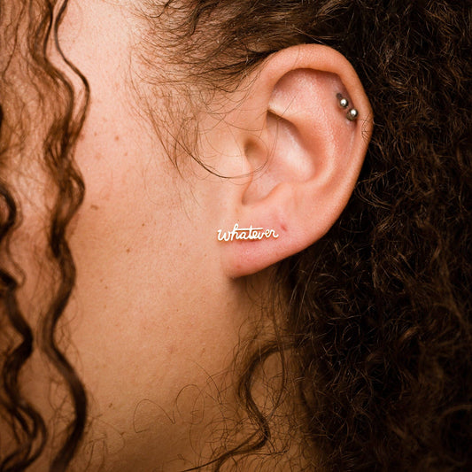 person wearing a gold whatever stud earring