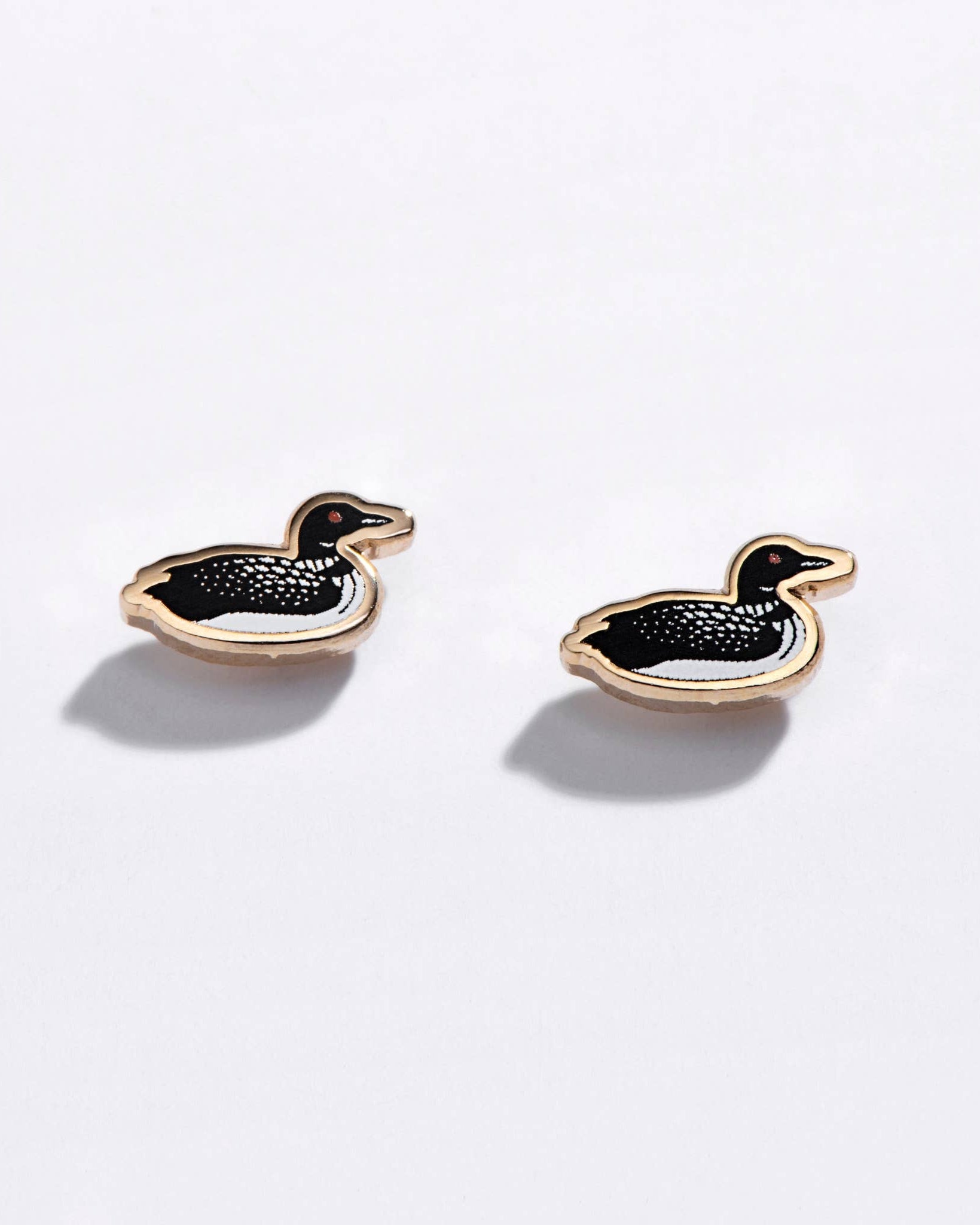 loon-shaped earrings on a light gray background