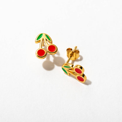 Gold cherry earrings with red enamel on a white background