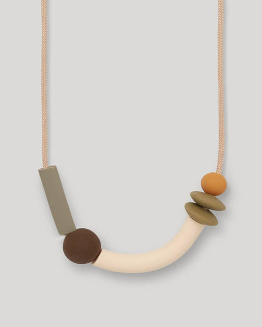 Teething Necklace with geometric beads on a light gray background