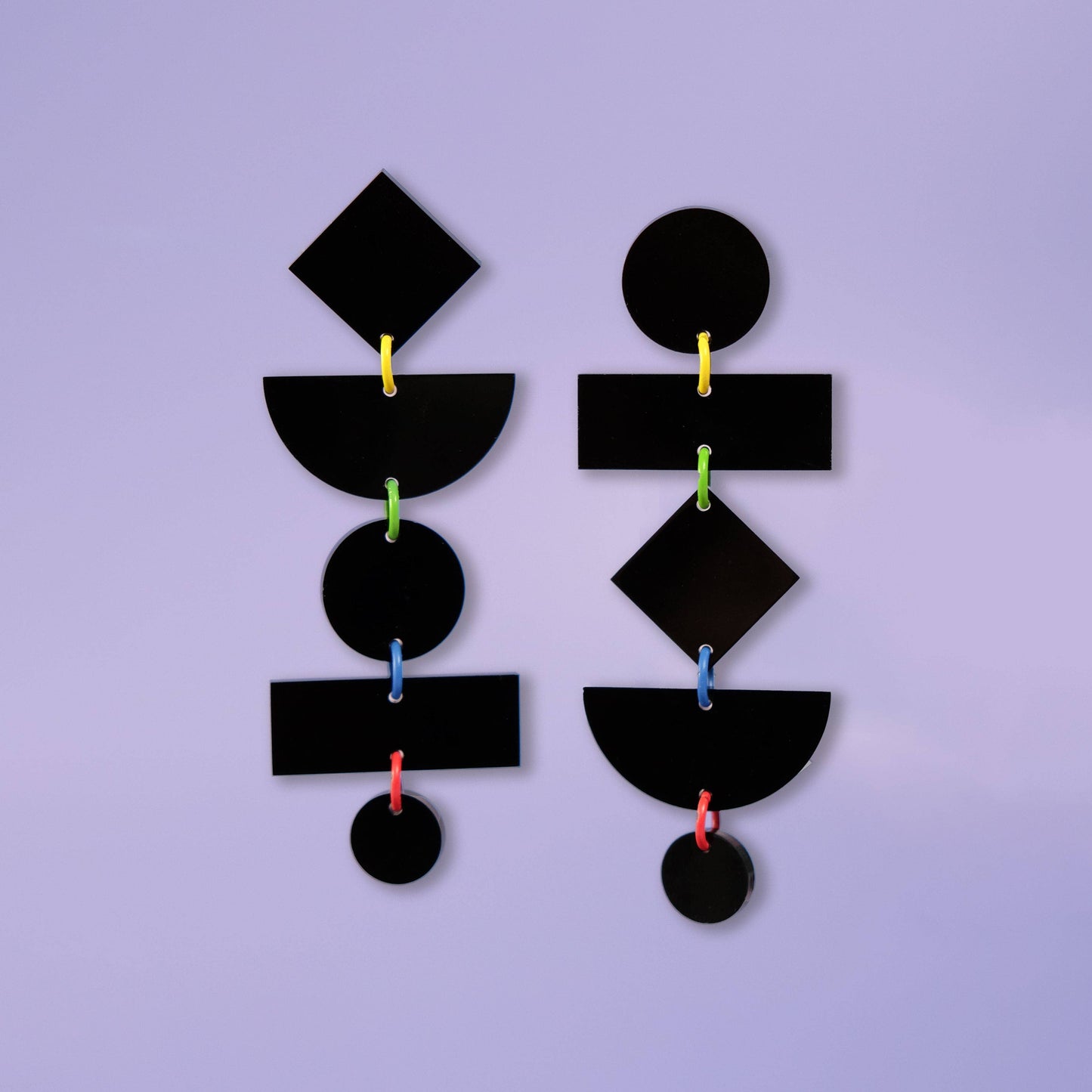 Black geometric earrings on a purple background