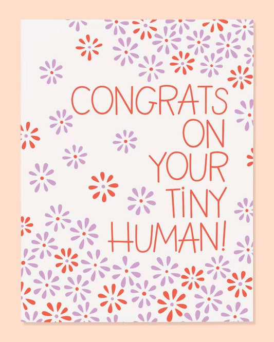 Greeting card with floral pattern and text 'Congrats on your tiny human!' on a light pink background