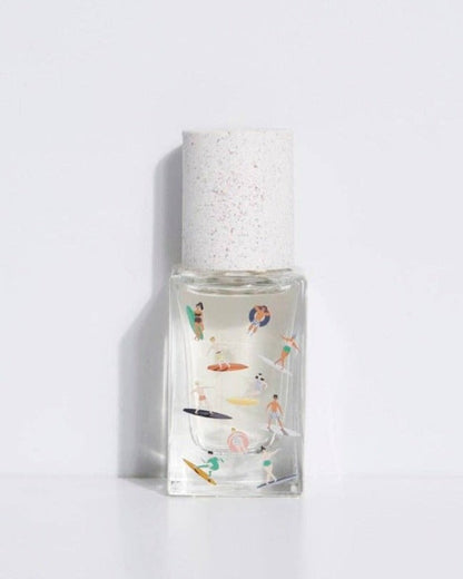 A bottle of Bain de Midi EDP with a decorative pattern on the white cap and a clear glass body showing the liquid inside.