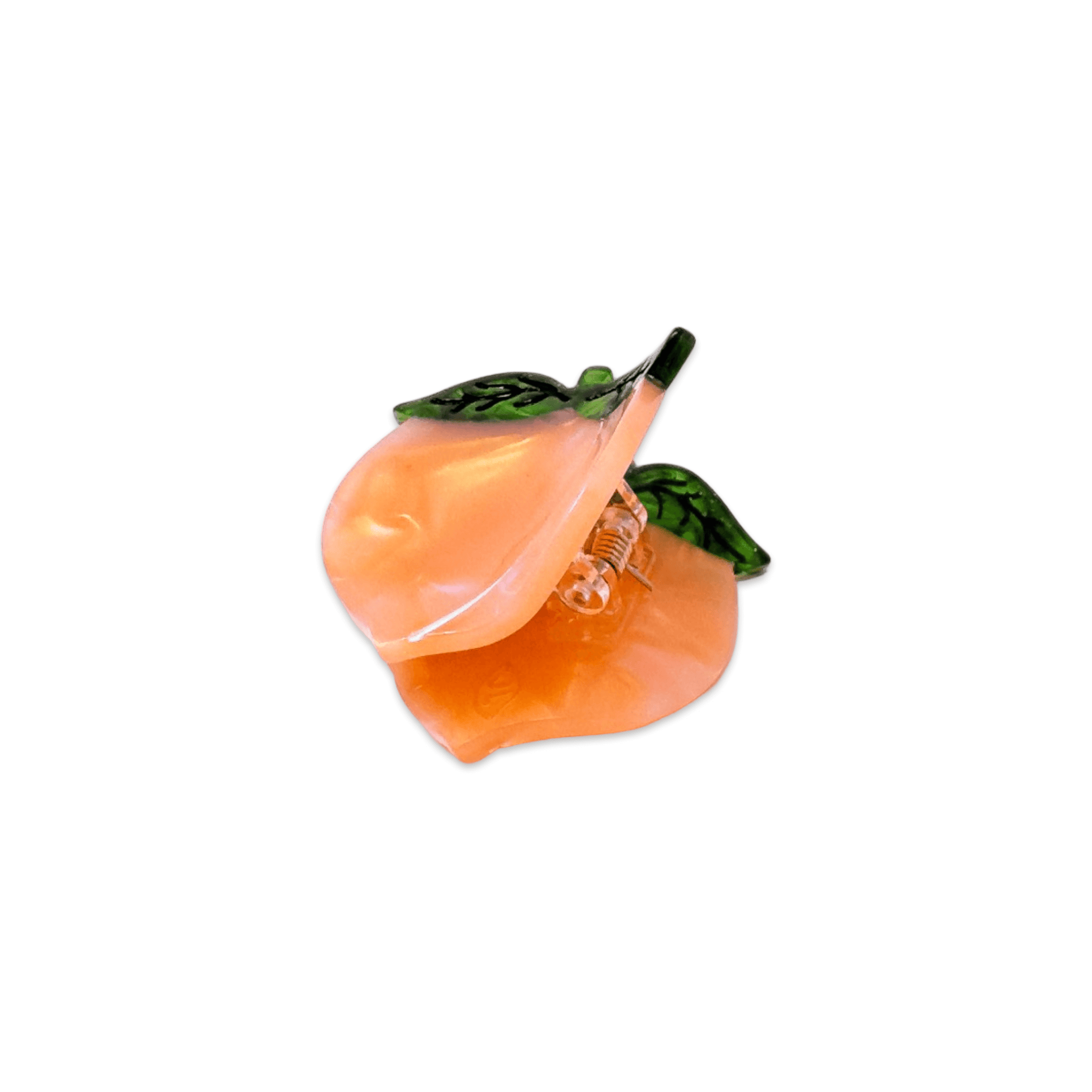 Peach-shaped hair clip with green leaves on a white background